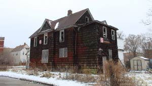 A picture of a blighted property covered in snow.